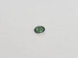a green tourmaline gems on a white surface