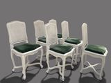 four white cane back chairs with green cushions on a grey background