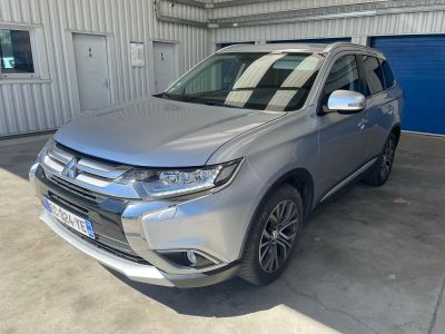 un SUV argenté garé dans un garage, à côté d'une porte de garage bleue