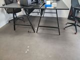 a desk with a laptop and a chair in the corner