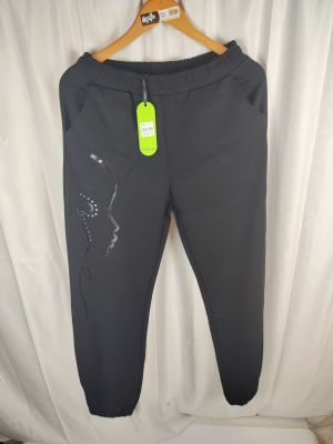 Le pantalon est noir et porte une étiquette verte.