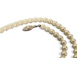 a close up of a pearl necklace on a white background