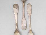 three spoons and two forks sitting on a table
