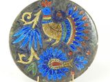 a blue plate with a bird on it on a stand