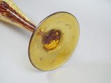 a glass vase that has a gold decoration on it