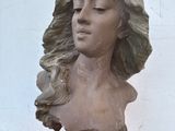 une statue représentant une femme aux longs cheveux, posée sur une table en bois