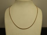 Le collier est présenté sur un mannequin devant un fond blanc.