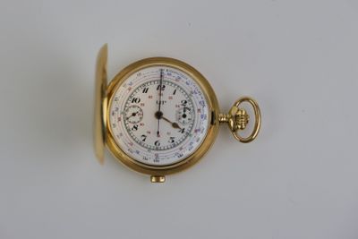une montre de poche en or sur une surface blanche