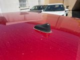 a red car that has a shoe on the hood of it