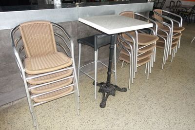 plusieurs chaises et une table dans un restaurant, avec un bar en arrière-plan