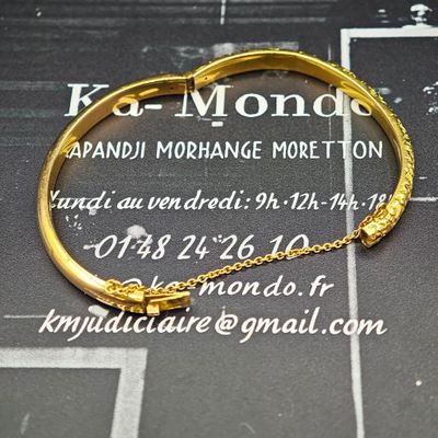 bracelet en or avec une chaîne et un fermoir sur fond noir