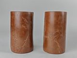 deux vases marron ornés d'oiseaux et de fleurs, posés sur une table