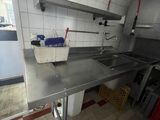 a kitchen with a sink and a counter with a bucket on it