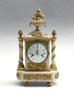 une horloge blanche et or posée sur une table