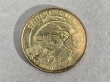 a close up of a gold coin with a picture of a man on it
