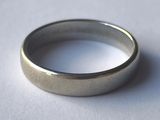 une bague en argent posée sur une surface blanche