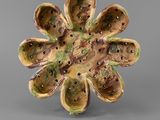un gros plan d'un objet en forme de fleur posé sur une surface grise