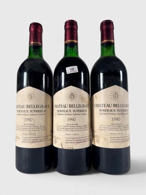 trois bouteilles de vin rouge posées l'une à côté de l'autre sur une surface blanche