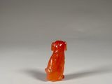 an orange gummy bear sitting on top of a white surface
