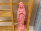 a small statue of a woman on a shelf next to a basket of eggs