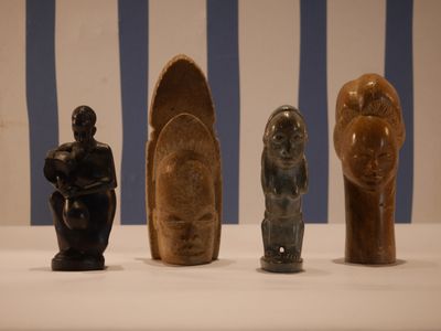 Plusieurs types de sculptures sont exposés sur une surface blanche