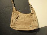beige leather purse with zippers and zippers hanging from it
