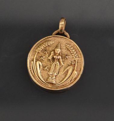 Un médaillon pendentif en métal doré représentant la divinit…