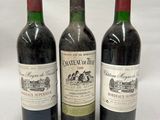 three bottles of wine are lined up on a white surface