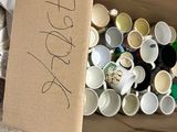 a cardboard box full of empty cups and a pair of scissors