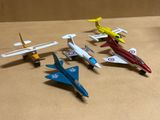 cinq petits avions en jouet posés sur une table