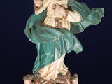 an antique statue of a woman sitting on top of a fire hydrant