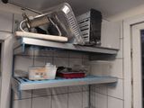 a metal shelf that has some pots and pans on it