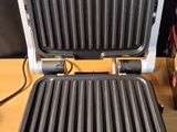a black and silver electric grill on a wooden table
