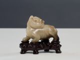 Figurine chinoise en ivoire sculpté représentant un lion, posée sur un socle