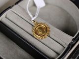une médaille d'or dans un écrin orné d'un ruban blanc