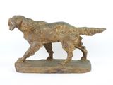 statue d'un golden retriever posée sur un socle en bois, sur fond blanc
