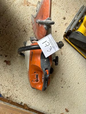 a small chainsaw sitting on the floor next to a tool box