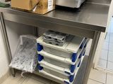 une table de travail en acier inoxydable sur laquelle sont posées plusieurs boîtes