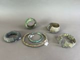 several different types of rings and bracelets are displayed on a table