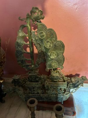 a statue of a boat on a table next to a vase
