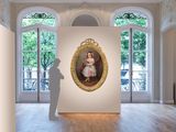 a picture of a woman standing in a room with a painting on the wall