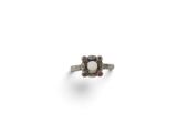 a close up of a ring with a pearl and garnets on it