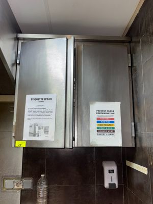 une photo de toilettes publiques avec un panneau accroché au mur