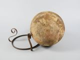 a large stone ball with a metal handle on it