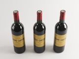 three bottles of wine sitting next to each other on a white surface