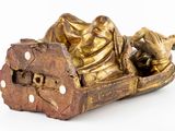 a gold statue of a person laying in a boat