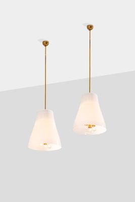 a pair of white and gold pendant lights hanging from a ceiling