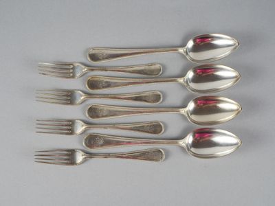 six cuillères en argent et une fourchette sont alignées sur une table