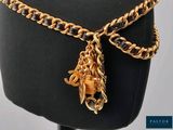 a black mannequin with a gold chain and a horse charm