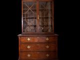 an antique wooden cabinet with glass doors and drawers